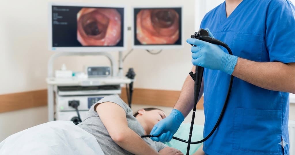 Medic explicând procedura de endoscopie digestivă superioară unei paciente.