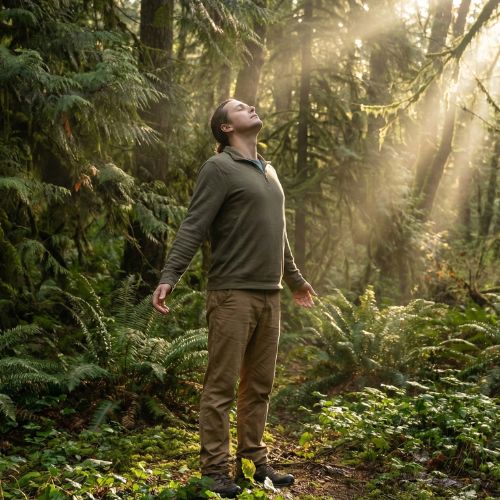 Persoană inspirând adânc aer curat în natură, ilustrând procesul natural de curățare a plămânilor și regenerare pulmonară după renunțarea la fumat.