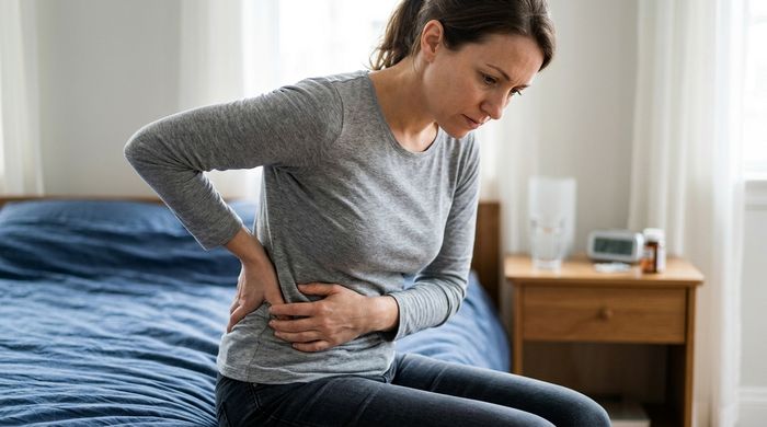 Femeie cu durere în flanc, arătând exact unde dor rinichii